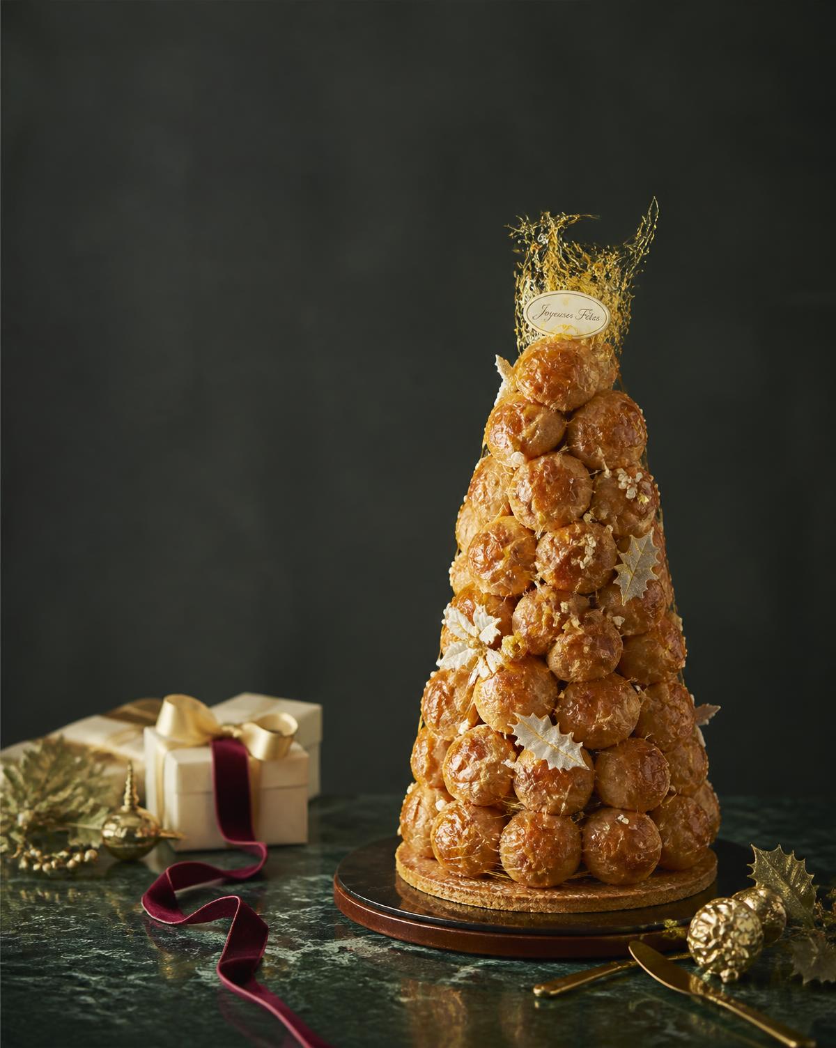 Croquembouche de Natal montada com fios de caramelo dourado